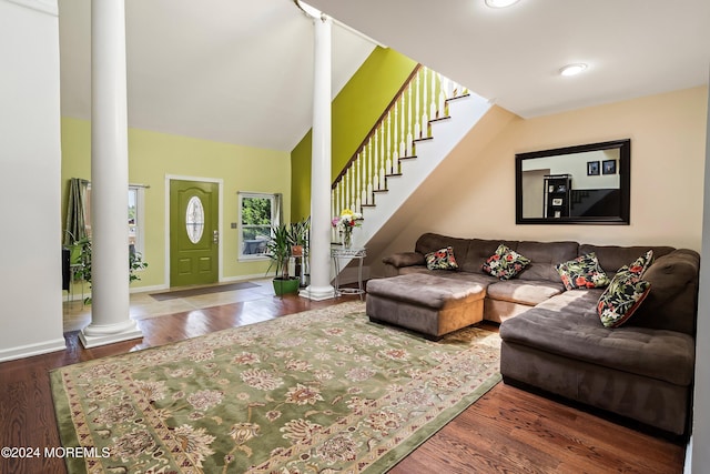 living room with ornate columns, dark hardwood / wood-style flooring, and lofted ceiling