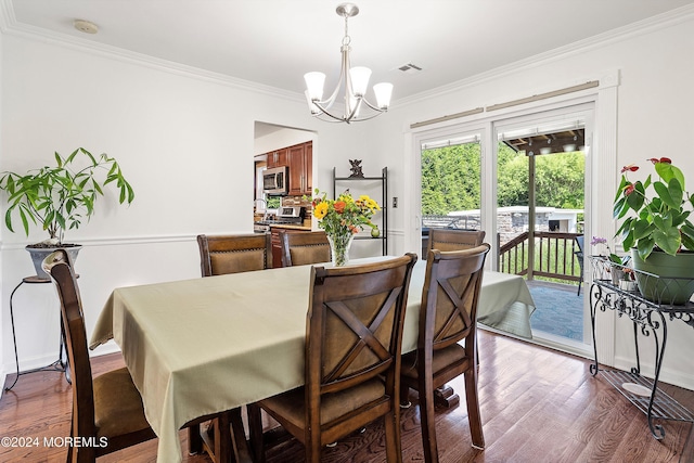 dining area featuring ornamental molding, dark wood-type flooring, and a chandelier