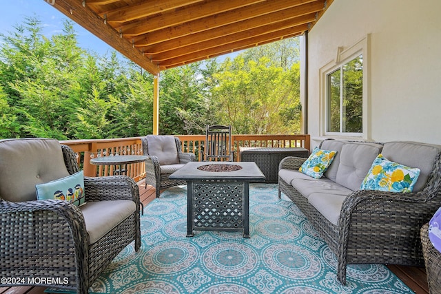 wooden terrace featuring an outdoor living space with a fire pit