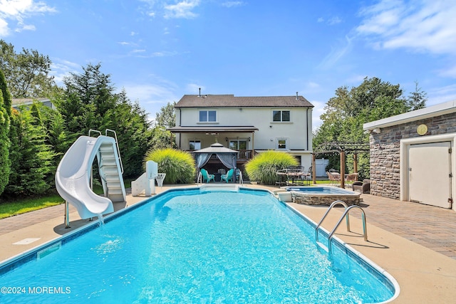 view of swimming pool with an in ground hot tub, a patio area, and a water slide