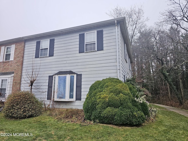 view of side of home with a yard