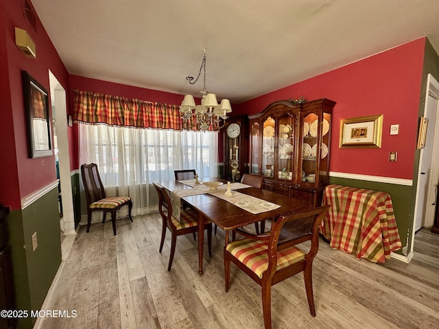 dining space featuring an inviting chandelier and hardwood / wood-style floors