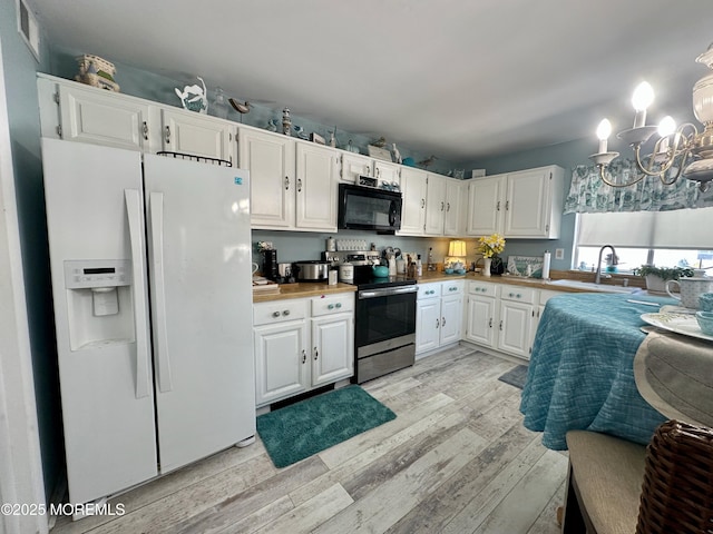 kitchen with stainless steel range with electric stovetop, white refrigerator with ice dispenser, light hardwood / wood-style floors, and white cabinets