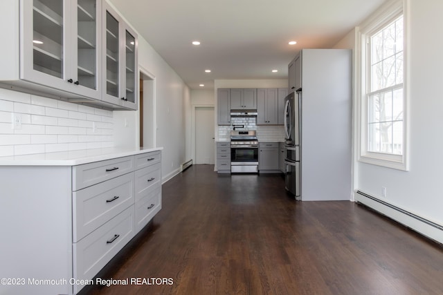 kitchen with decorative backsplash, appliances with stainless steel finishes, gray cabinets, and plenty of natural light