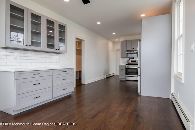 kitchen with stainless steel range, decorative backsplash, a baseboard radiator, and gray cabinets