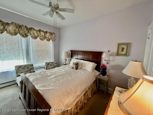 bedroom with ceiling fan, carpet floors, and baseboard heating