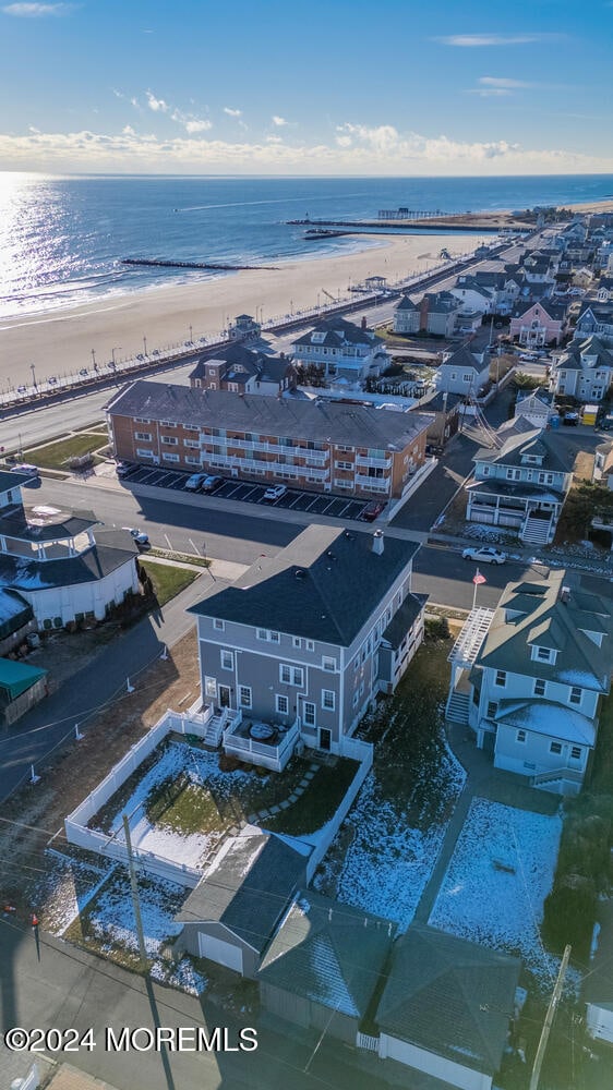 bird's eye view featuring a water view and a beach view