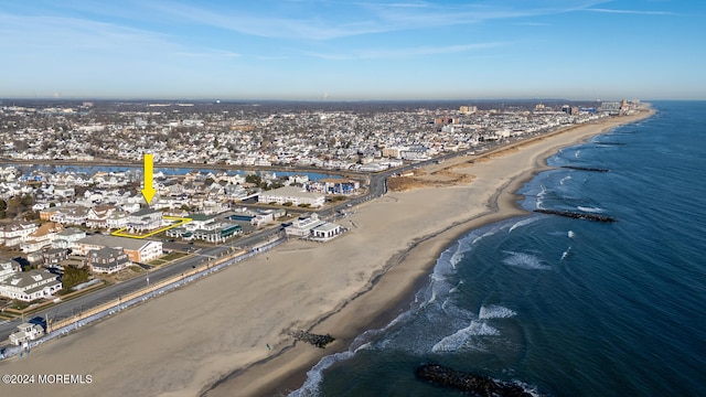 birds eye view of property with a water view and a beach view