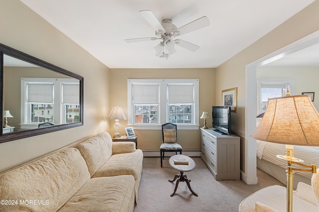 living room featuring a healthy amount of sunlight, ceiling fan, a baseboard radiator, and light carpet