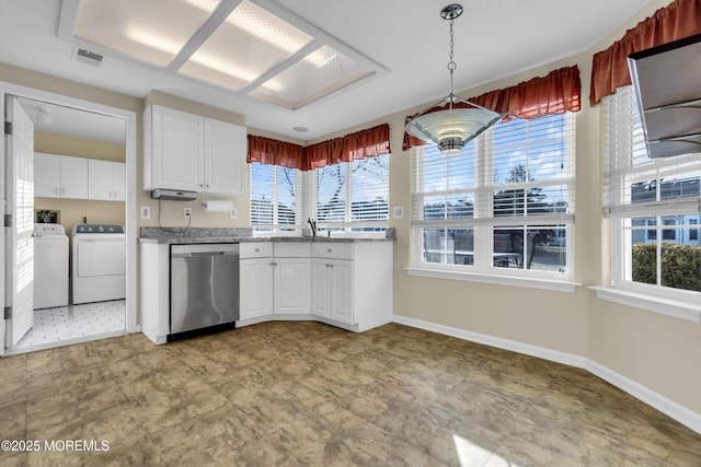 kitchen with a healthy amount of sunlight, separate washer and dryer, hanging light fixtures, stainless steel dishwasher, and white cabinets