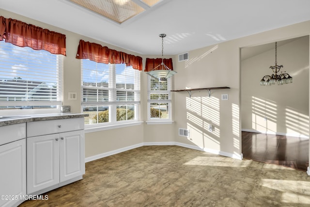 unfurnished dining area featuring a notable chandelier