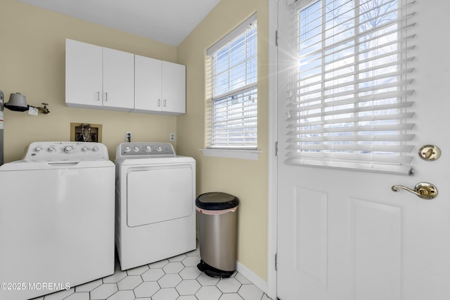 laundry room with washing machine and dryer and cabinets