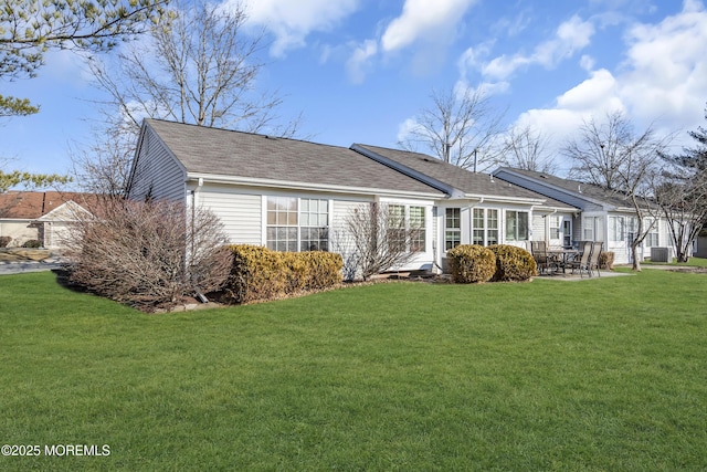 rear view of house with a patio area, central air condition unit, and a lawn