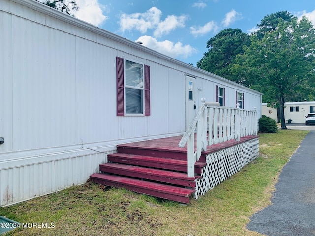 view of front of house with a wooden deck and a front yard