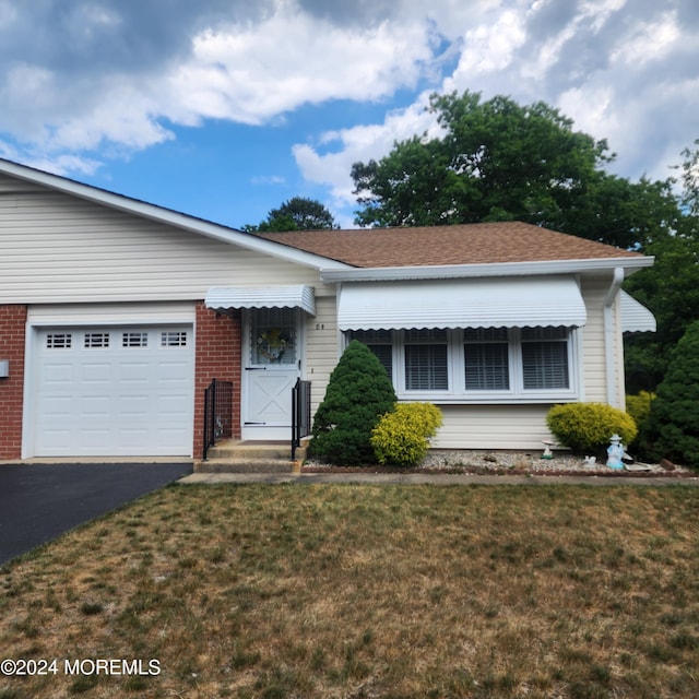 view of front of property featuring a garage and a front lawn