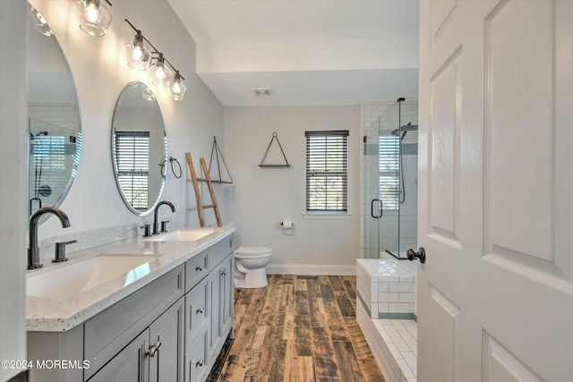 bathroom featuring an enclosed shower, vanity, hardwood / wood-style floors, and toilet