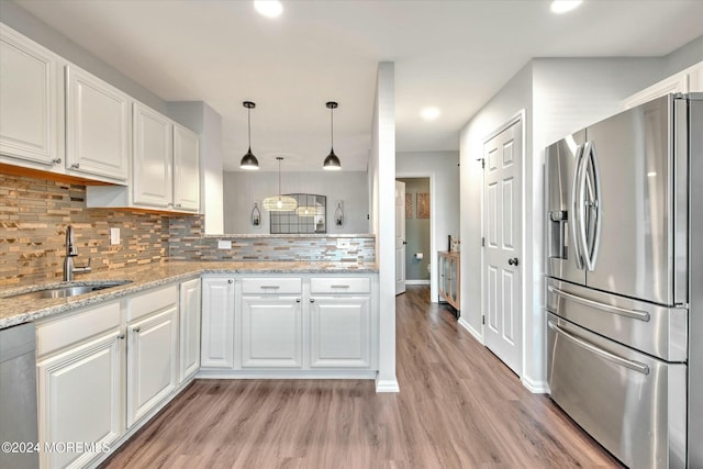 kitchen featuring appliances with stainless steel finishes, tasteful backsplash, sink, white cabinets, and light stone countertops