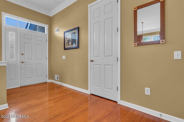 entryway featuring crown molding and light hardwood / wood-style floors