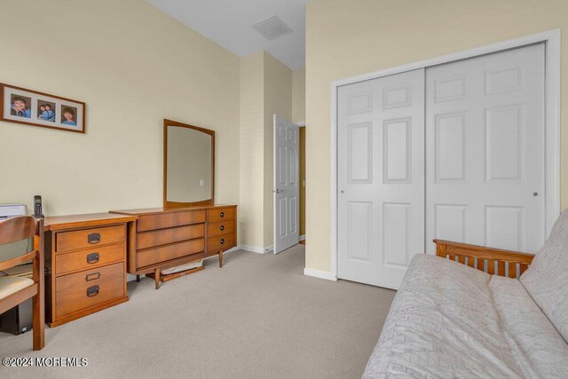 bedroom featuring light carpet and a closet