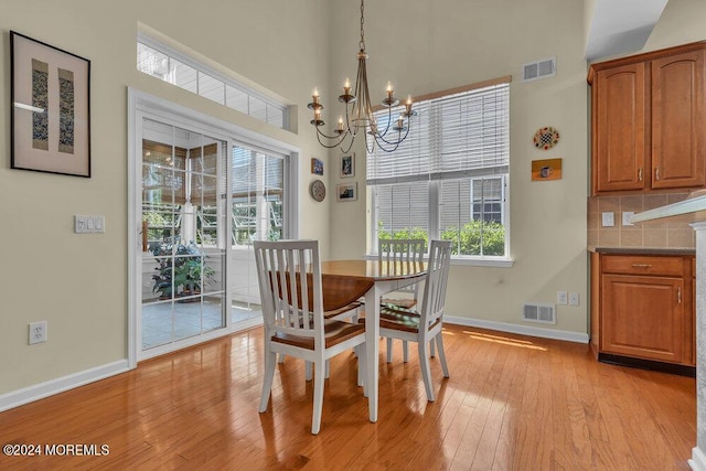 dining room featuring light hardwood / wood-style flooring, a wealth of natural light, and a notable chandelier