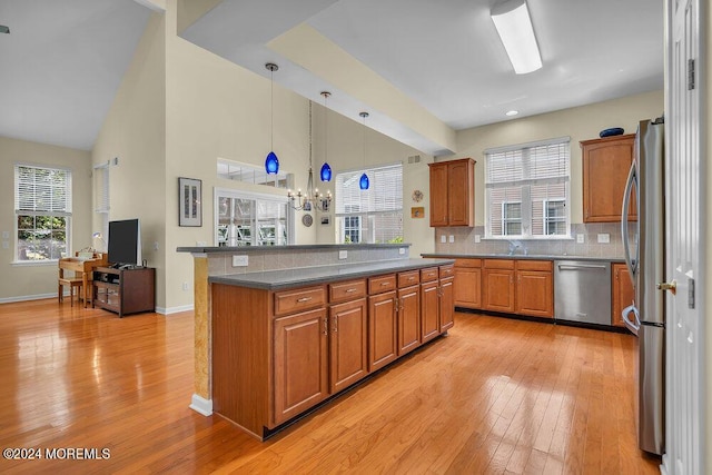 kitchen with a chandelier, pendant lighting, a center island, and stainless steel appliances