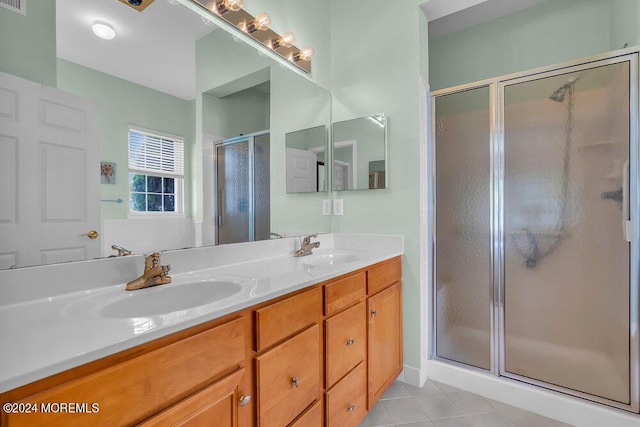 bathroom featuring tile patterned floors, vanity, and a shower with door