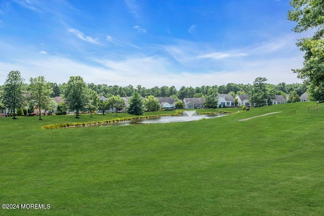 view of community with a water view and a yard