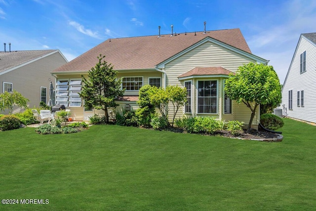 back of property with a yard and central air condition unit