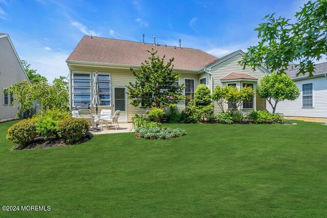 rear view of house with a lawn and a patio area