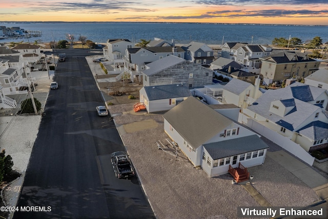 aerial view at dusk featuring a water view