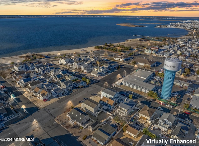 aerial view at dusk featuring a water view