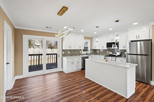 kitchen with a center island, sink, stainless steel appliances, pendant lighting, and white cabinets