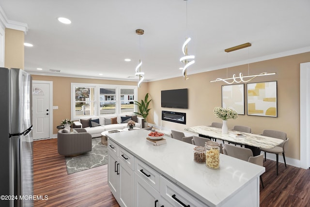 kitchen featuring dark wood-type flooring, hanging light fixtures, a kitchen island, white cabinetry, and stainless steel refrigerator