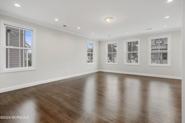 spare room featuring dark hardwood / wood-style flooring and crown molding