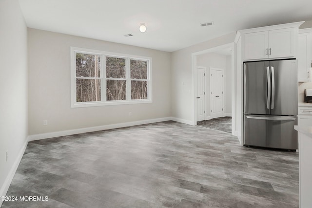 kitchen with stainless steel fridge and white cabinetry