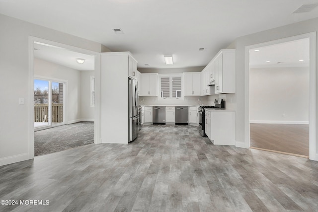 kitchen with white cabinets, appliances with stainless steel finishes, and light hardwood / wood-style floors