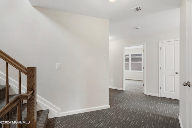 hallway with dark colored carpet