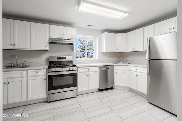 kitchen featuring white cabinetry, sink, light tile patterned flooring, and stainless steel appliances