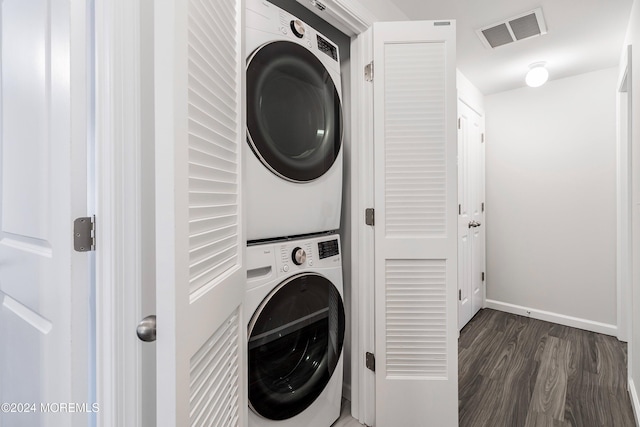 laundry room with dark wood-type flooring and stacked washing maching and dryer