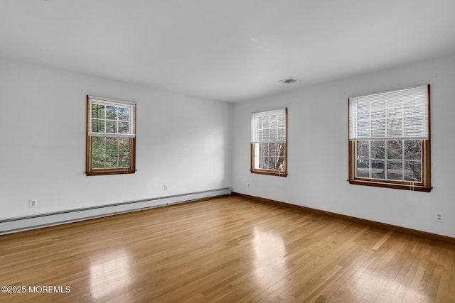 unfurnished room with light hardwood / wood-style flooring and baseboard heating