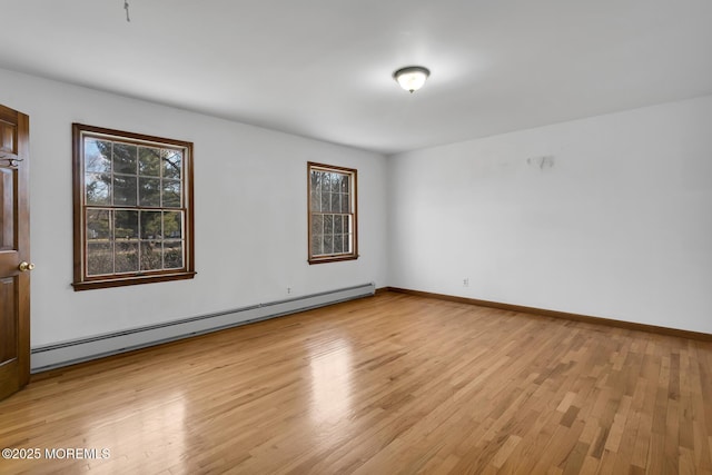 unfurnished room with a baseboard radiator and light hardwood / wood-style floors