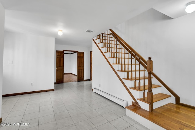 staircase featuring tile patterned flooring and baseboard heating