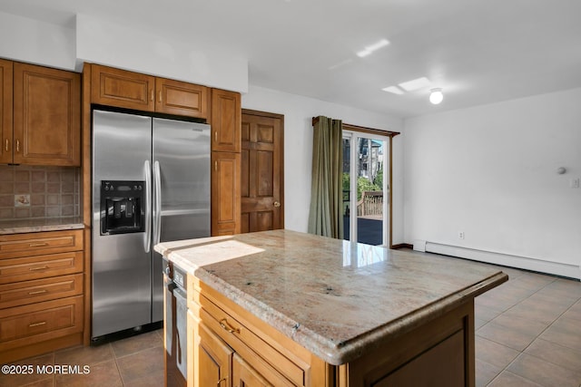 kitchen featuring a baseboard heating unit, light stone countertops, tasteful backsplash, a kitchen island, and stainless steel appliances