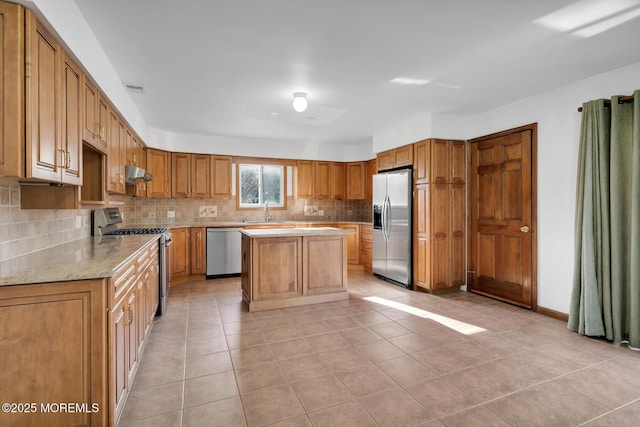 kitchen featuring sink, light tile patterned floors, tasteful backsplash, a kitchen island, and stainless steel appliances