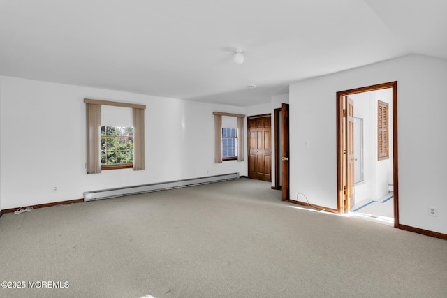 spare room with vaulted ceiling, light colored carpet, and a baseboard heating unit