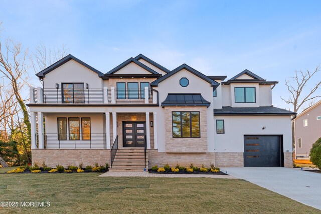 view of front of home featuring covered porch, a garage, a balcony, and a front yard