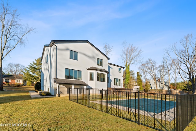 rear view of house featuring a covered pool, a patio area, and a lawn