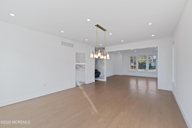 unfurnished living room featuring light hardwood / wood-style floors and a notable chandelier