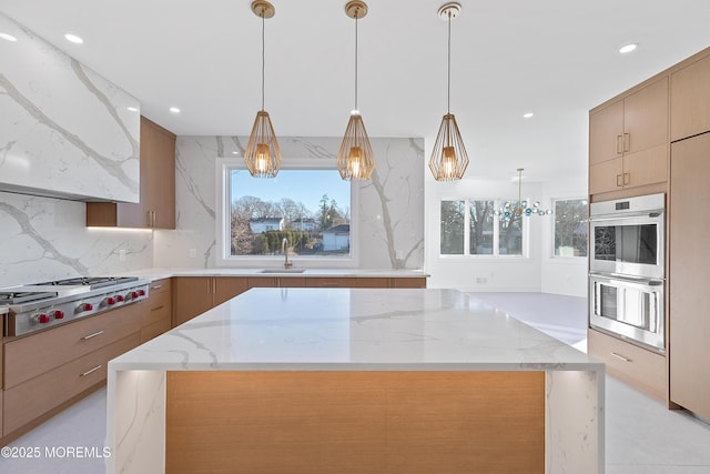 kitchen with hanging light fixtures, tasteful backsplash, light stone counters, ventilation hood, and appliances with stainless steel finishes