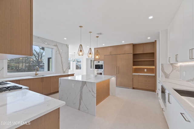 kitchen featuring white cabinets, hanging light fixtures, light stone countertops, paneled fridge, and a kitchen island